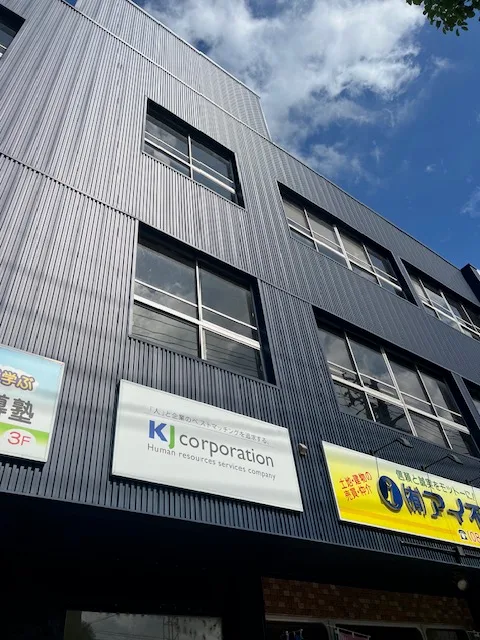 KJコーポレーションの看板がある新居浜ビジネスセンター第3ビルの外観
